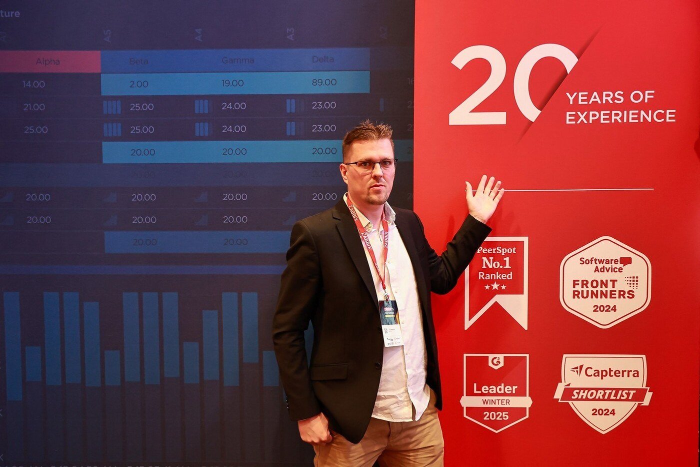 Alexander Fox vor dem '20 Years of Experience'-Banner mit Zabbix-Auszeichnungen